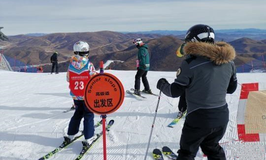 崇礼太舞滑雪场，小滑雪者在教练的带领下即将从高级道滑下。