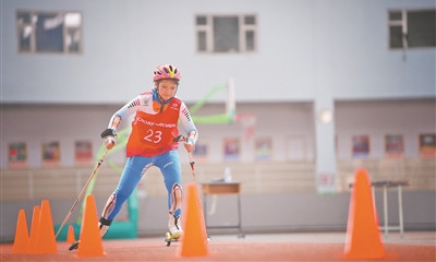 第二届全国学校冰雪运动竞赛越野滑轮项目中，小学女子组选手正奋力竞速